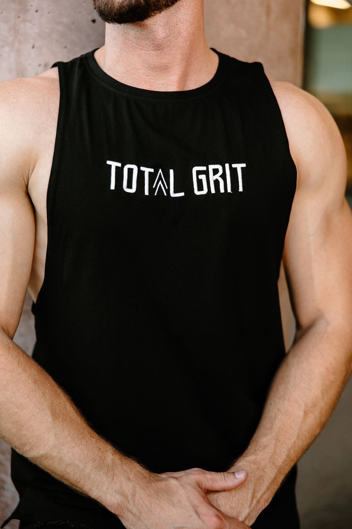 Close up of the custom embroidery on the Total Grit black cut-off tank.