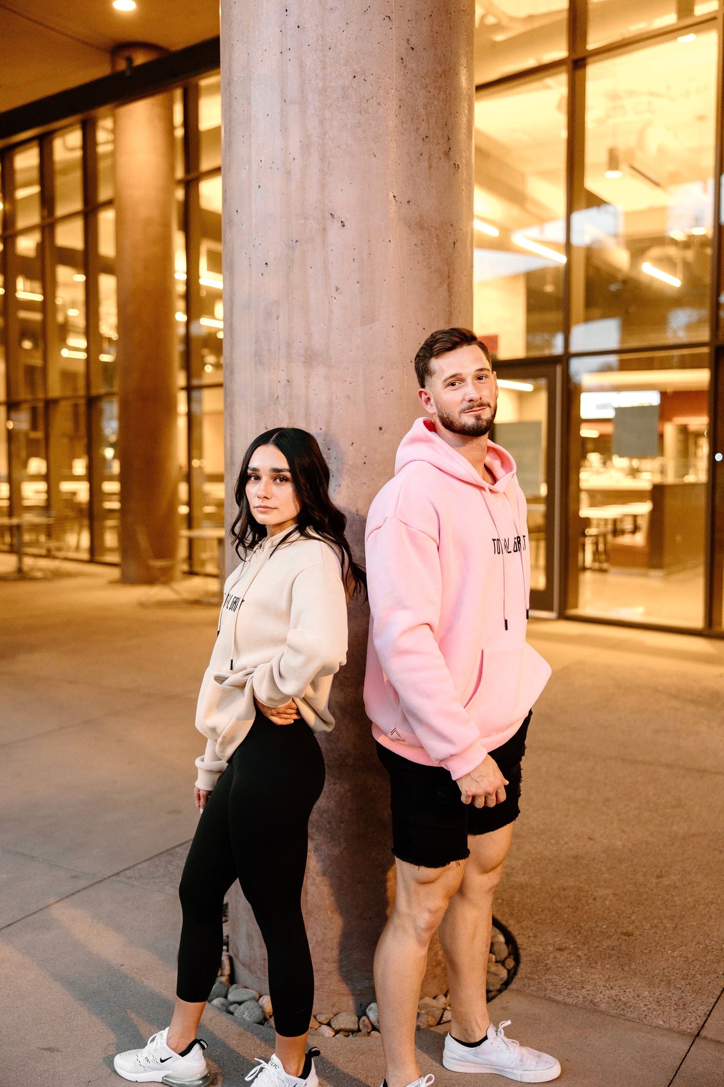 Duo shot of the khaki and light pink Pastel Hoodies. Can be worn to bundle up on a cold night, out on the town, or as a pump cover for your workouts!