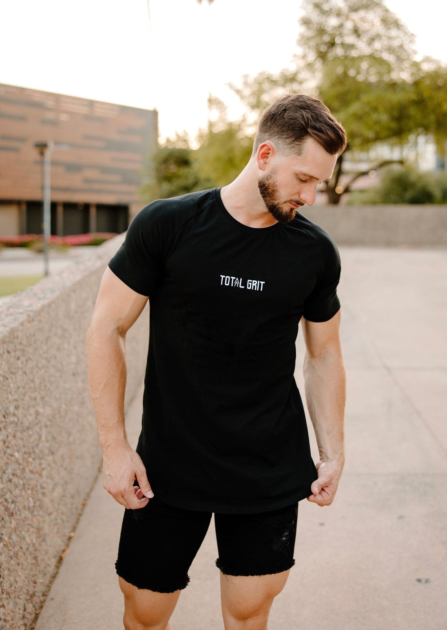 Model showing off our white logo on black fitted tee in Arizona's urban atmosphere.