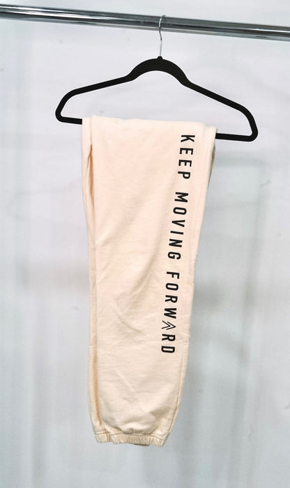 Close up detail of the cream sweats and KMF slogan.
